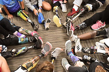 Group sitting in a circle with leg prosthetics pointing to the middle